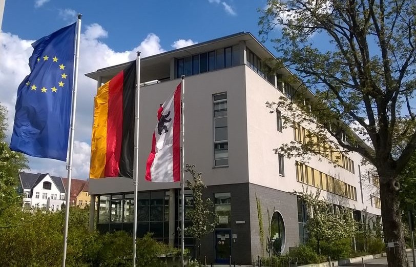 Schulgebäude der Peter-Ustinov-Schule mit Europa-, Deutschland- und Berlin-Flagge